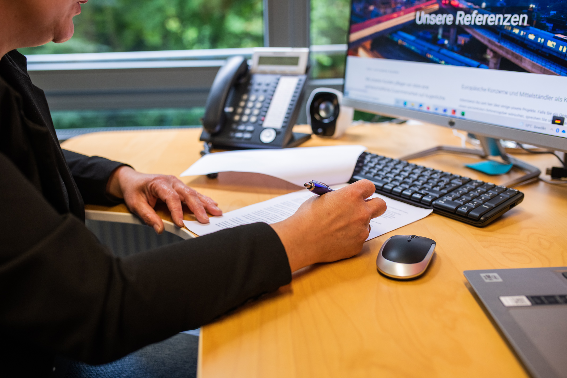 Arbeitsplatz im Wamser + Batra HQ Bochum. Eine Mitarbeiterin bearbeitet ein Dokument am Schreibtisch.