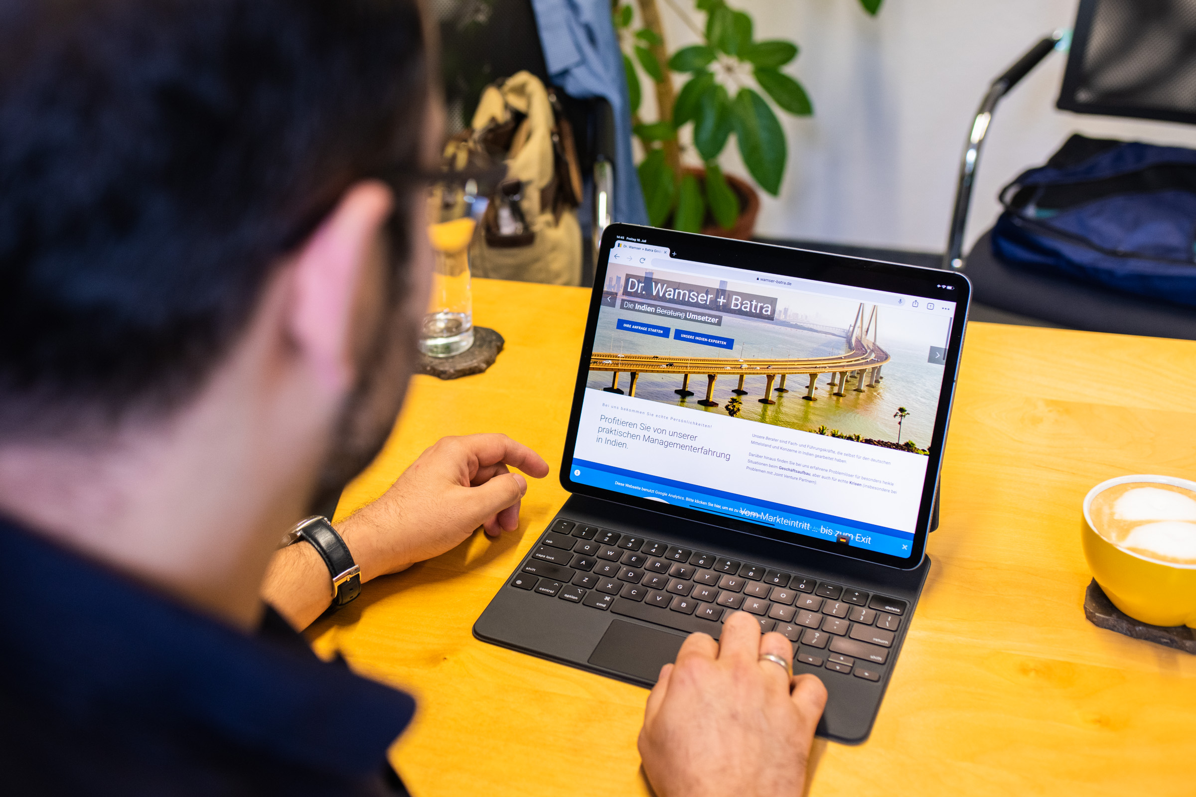 Mike D. Batra schaut auf den Laptop, der die WB-Unternehmenswebsite zeigt.