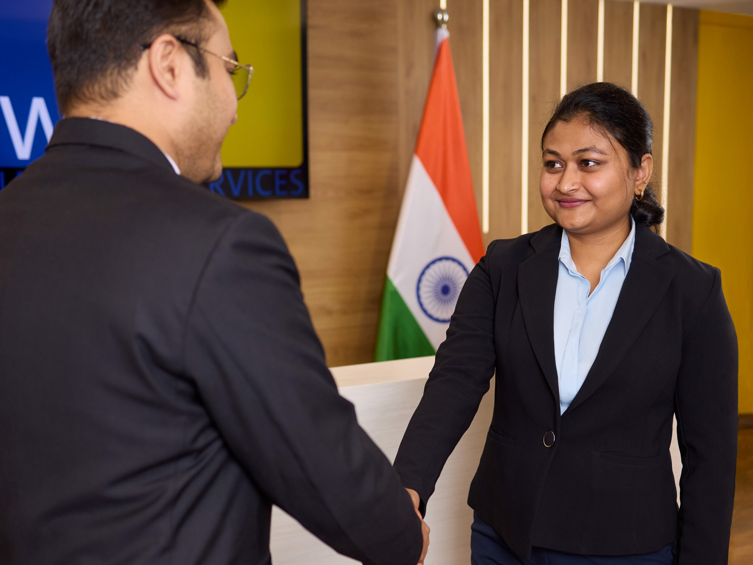 Varsha Pallavi schüttelt einem Kunden die Hand. Empfangsbereich Wamser + Batra HQ Delhi.