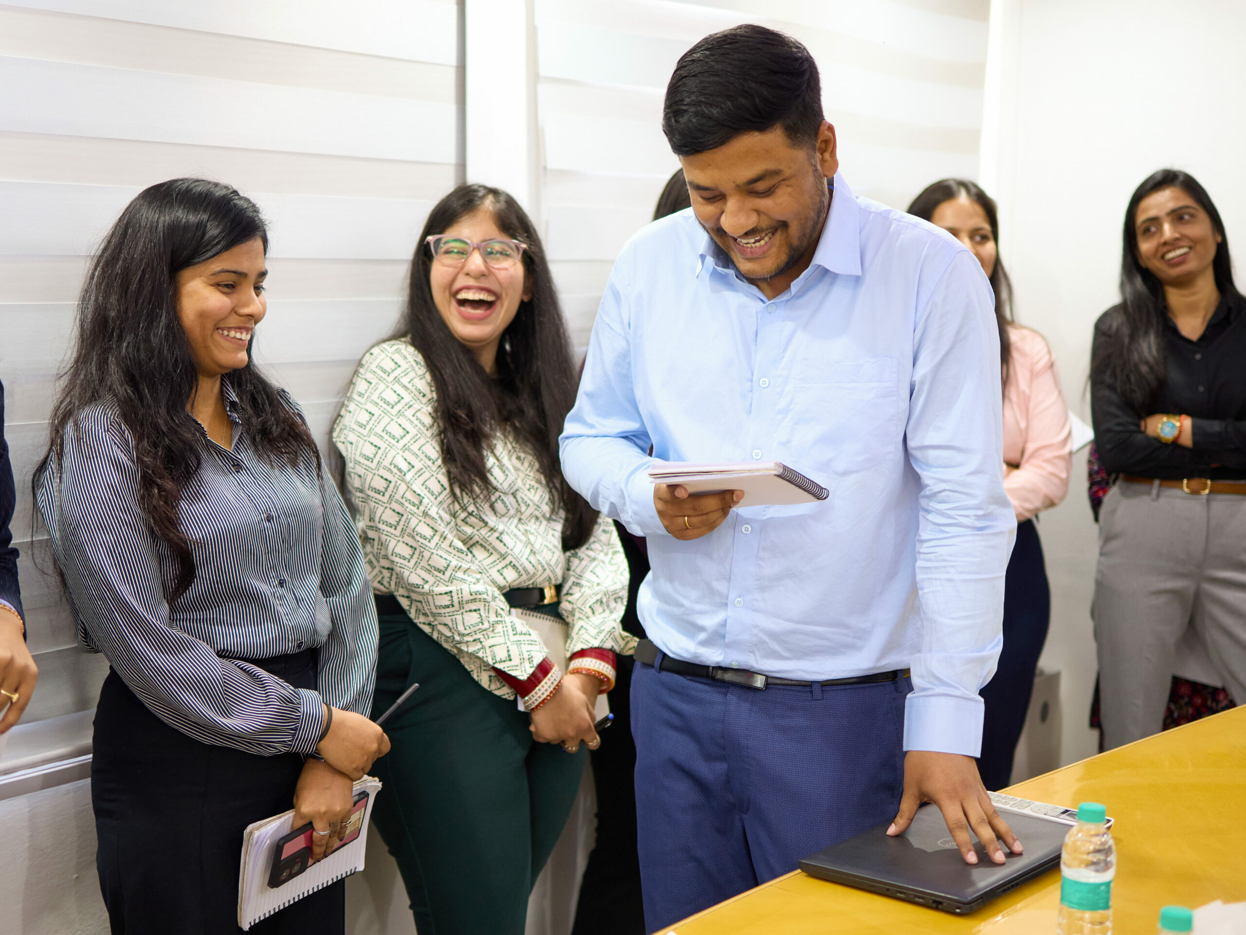 Gelöste Arbeitssituation im Wamser + Batra HQ Delhi. Ein Mitarbeiter überprüft seine Notizen, während seine Kolleginnen sich unterhalten.