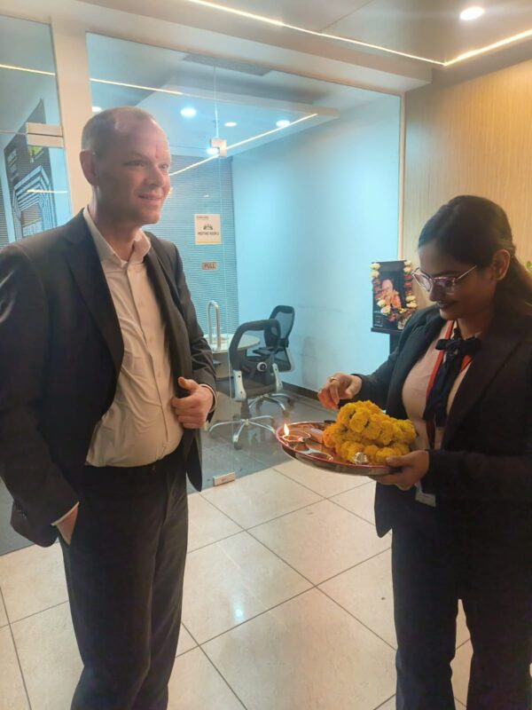 WB-Kunde vom Unternehmen Menzerna steht neben indischem Mitarbeiter. Das Foto wurde auf der Markterkundungsreise aufgenommen.