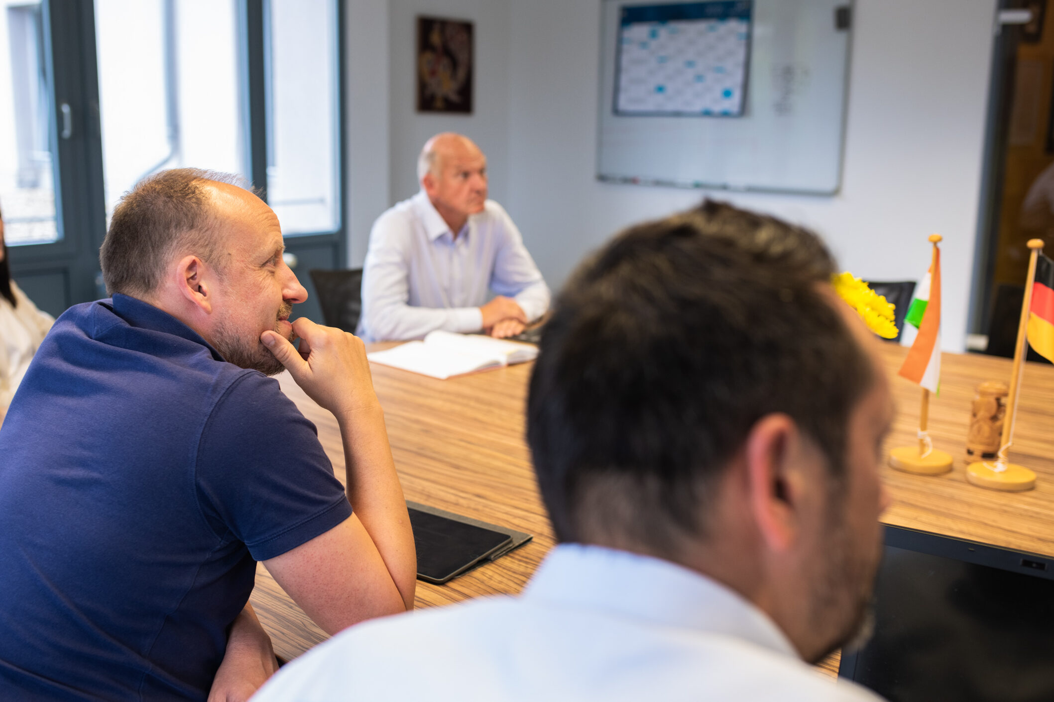 Dr. Johannes Wamser gemeinsam mit Kolleginnen und Kollegen an einem Konferenztisch im Wamser + Batra HQ Bochum während eines Strategiemeetings.